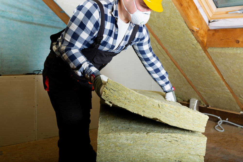 Man installing thermal roof insulation layer