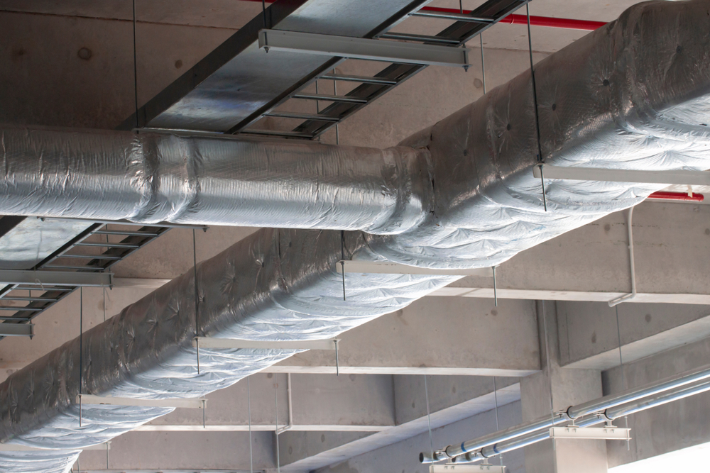 Air ducts wrapped in shiny silver fiberglass insulation