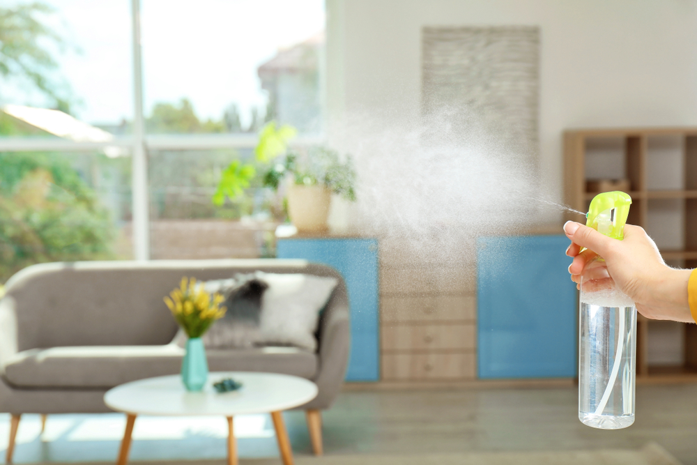 Spraying air freshener in home